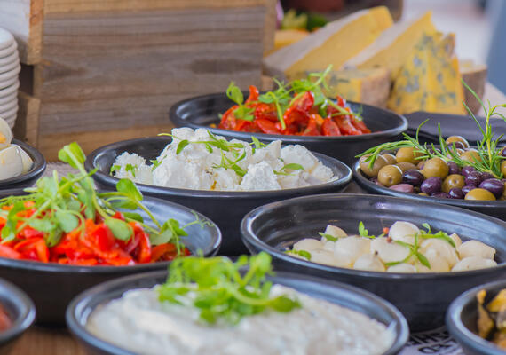 An assortment of food bowls including olives and basil