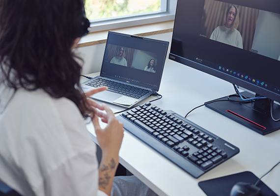 An over-the-shoulder view of a laptop and desktop screen