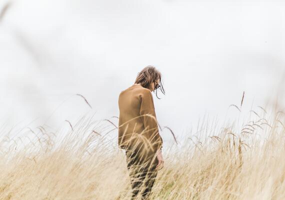A person standing alone in long grass.