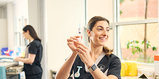 Deakin nursing student holds a syringe. 