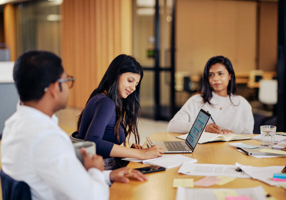 Postgraduate students in a corporate environment meeting or studying and interacting with each other