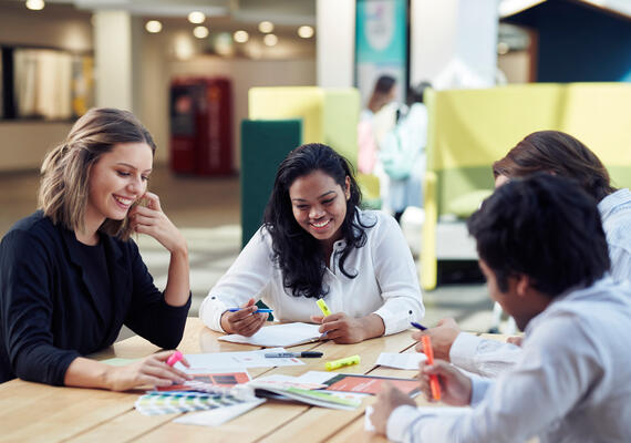 Group of Deakin accelerate students on campus sitting at table and smilling.