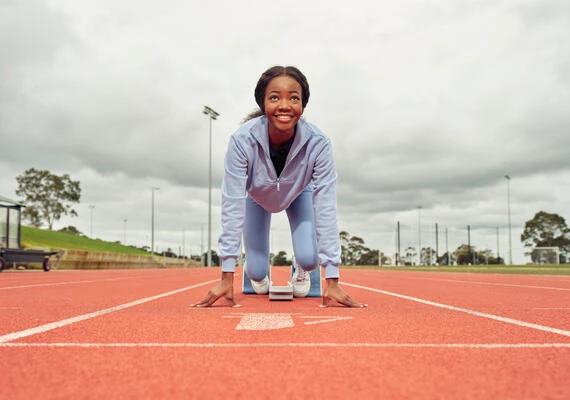 Person smiling at start line of athletics track