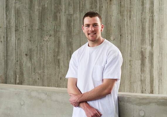 Deakin student Josh standing in front of a wall