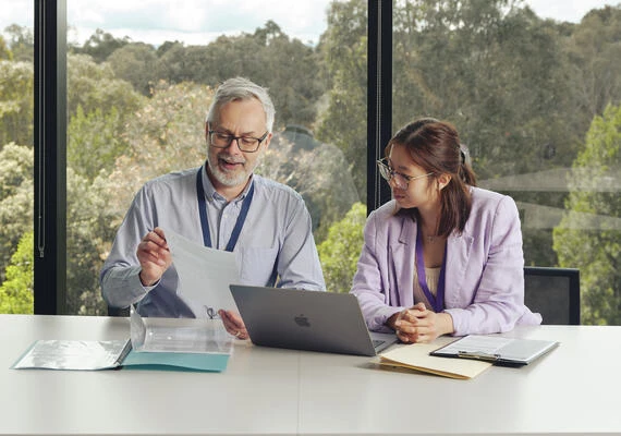 Two postgraduate health students sit talking at the Burwood campus