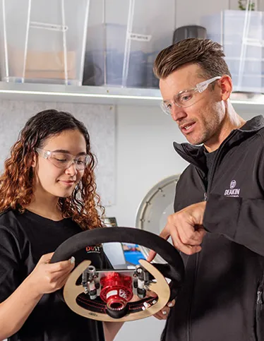 Deakin research supervisor showing research student how a steering wheel functions.