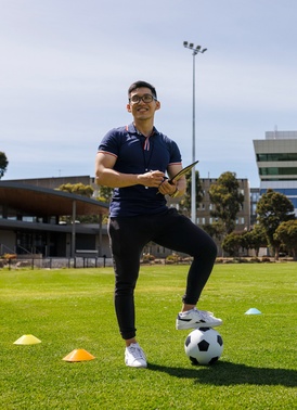 Student on oval with clipboard