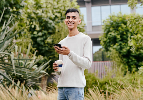 A student uses their phone outside.