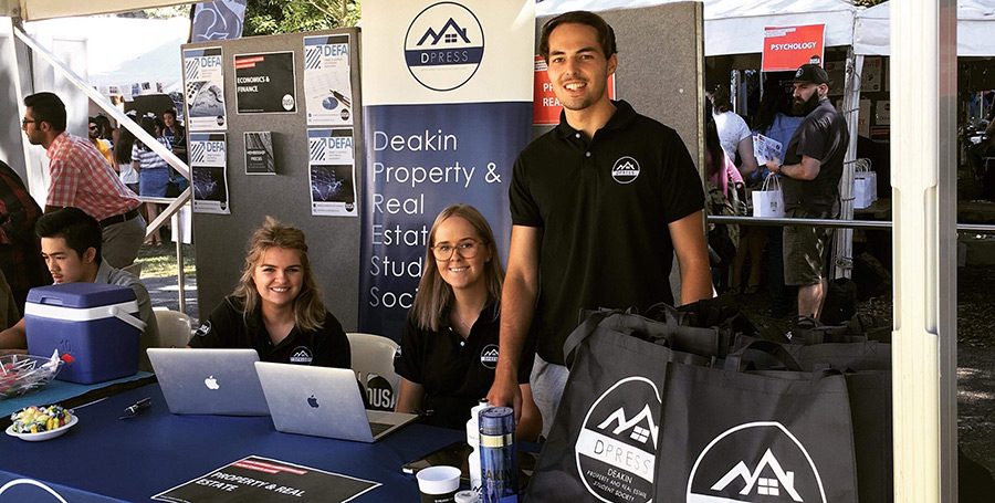 Daniel Telling stands at a Deakin OWeek 2018 stand representing the Property and Real Estate Student Society.