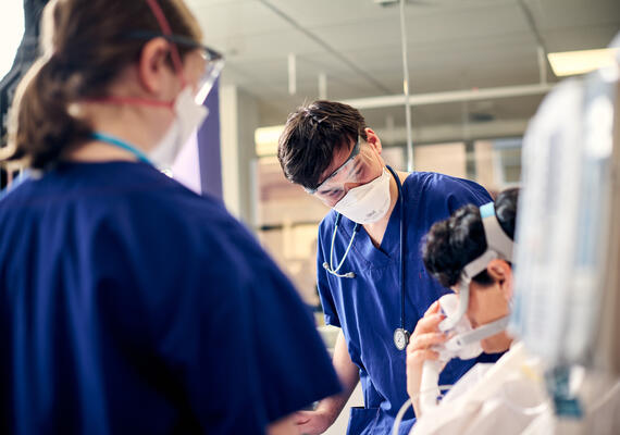 A group of health care professionals treat a patient in the emergency department.
