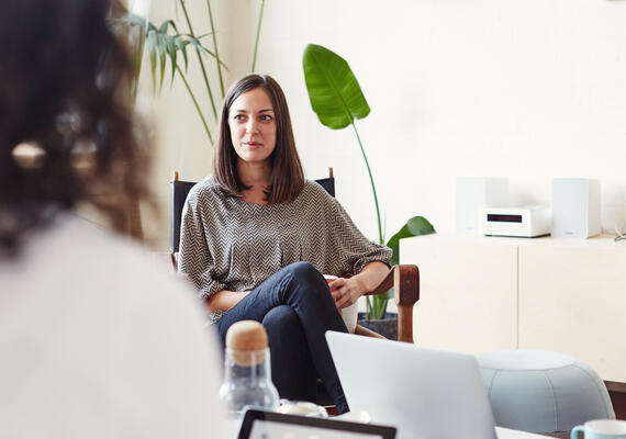 Person sitting in chair speaking with someone