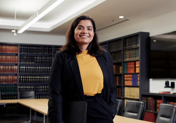 Student smiles in Victorian Bar Association library/meeting room.