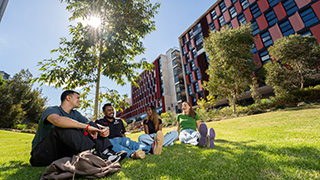 42427_320x180_Res_Burwood Four students enjoying a sunny afternoon on the lawn at Burwood residence