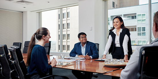 Four Deakin students in a boardroom.