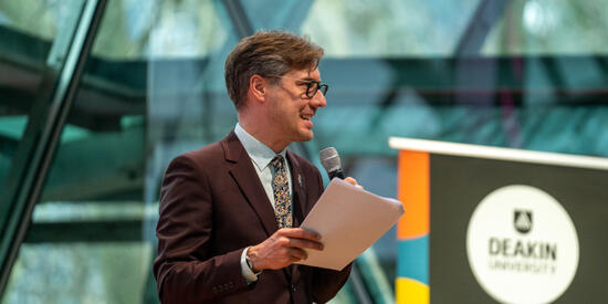 Senior lecturer Wade Kelly standing and talking on stage.