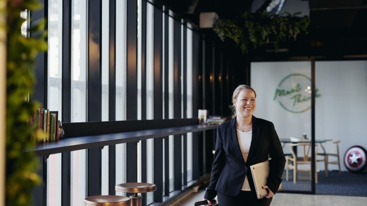 Female student walking in business attire in office