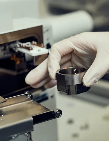 Deakin research student holding a machine part.