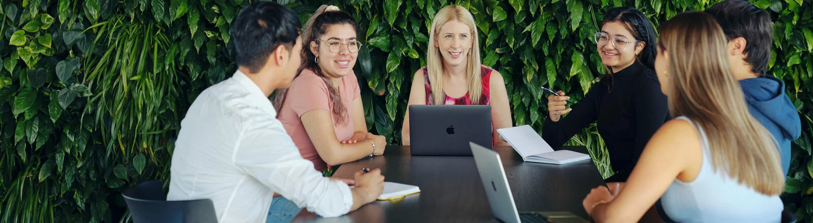 A group of Deakin master of counselling students sit around a table.