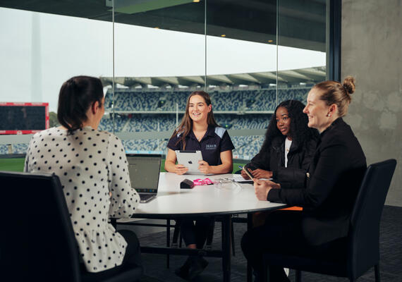 Students sitting at a table, discussing their work.