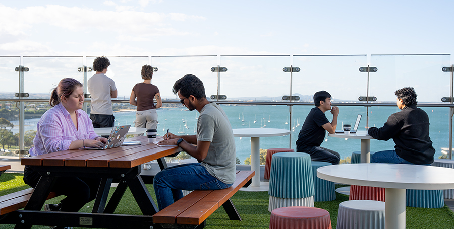 Students studying outside on a balcony overlooking the ocean