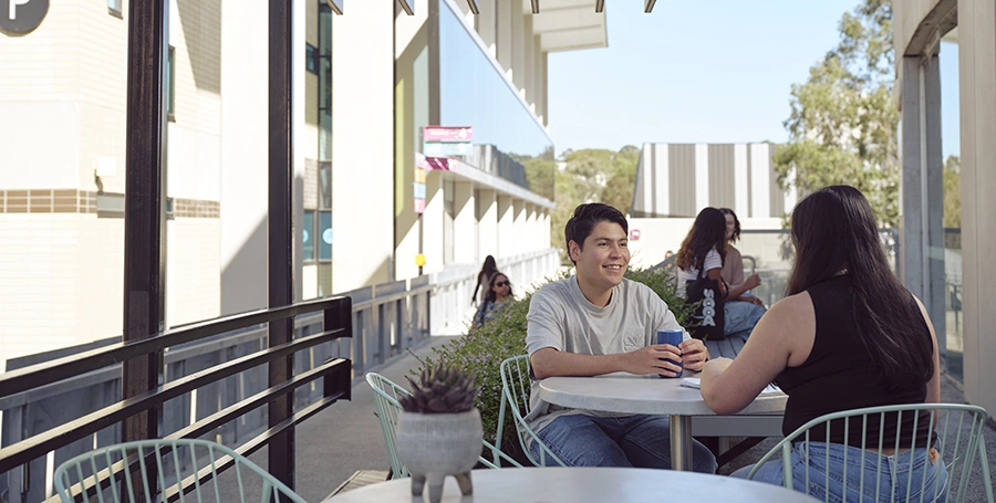 Deakin students sit outside at a cafe at Melbourne Burwood Campus.