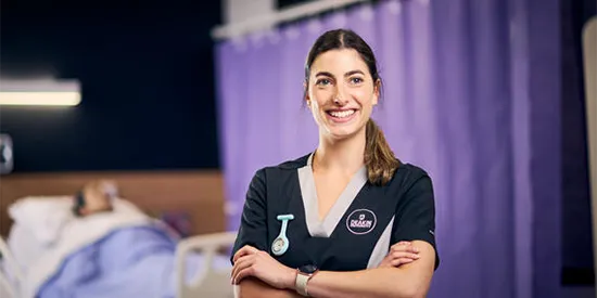 35407_550x275_nursing-ranking.webp Nursing student standing with crossed arms on a ward and smiling away from camera