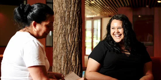 Deakin staff member and Deakin student smile while talking at the NIKERI Institute.