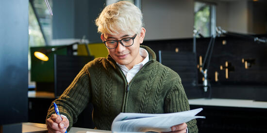 Student taking notes from a paper.