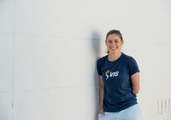 Person standing against a wall facing the camera