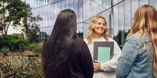Three students standing outdoors at Deakin