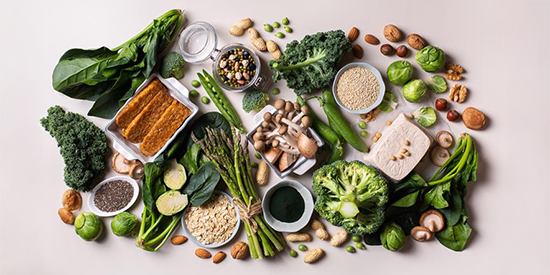 Variety of healthy vegan, plant-based protein source and body building food. Tofu soy beans tempeh, green vegetables, nuts, seeds, quinoa oat meal and spirulina.