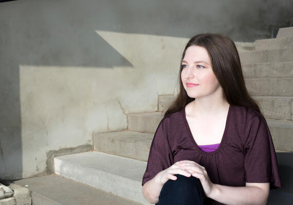 Bethany is sitting on concrete steps