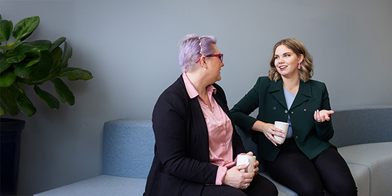 Two people sitting on a sofa having a discussion