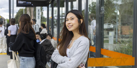 A Deakin student waiting for public transport at the bus stop outside Deakin university.