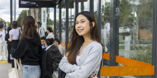 A Deakin student waiting for public transport at the bus stop outside Deakin university.
