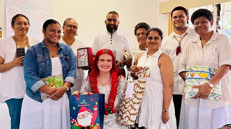 Sarah among a group of people at a Christmas celebration in Fiji