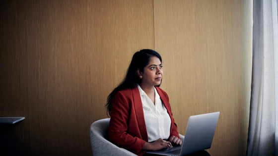 A student works on a laptop in a corporate office