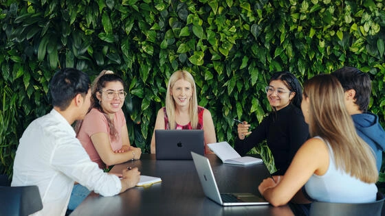 A group of Deakin master of counselling students sit around a table.
