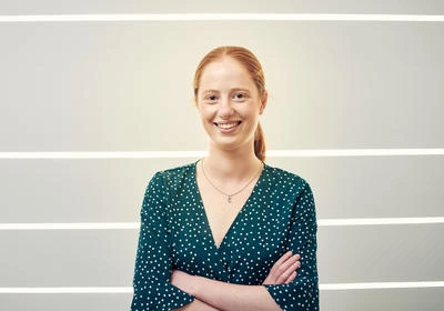 student with arms folded, smiling