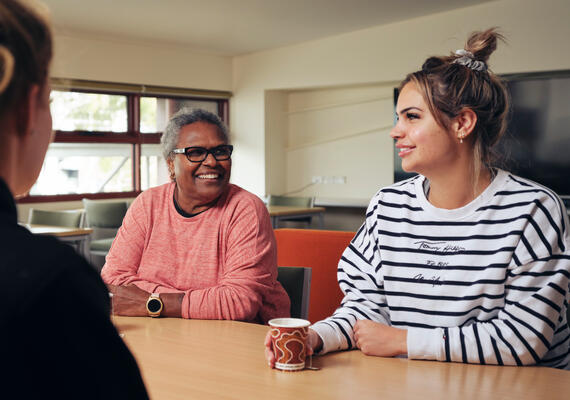 Three Deakin students sit around a table at NIKERI Institute. 