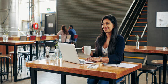 Student studying with laptop in cafe