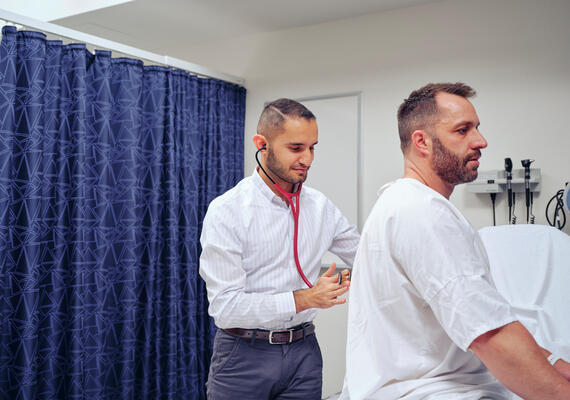 Student doctor attends to patient in hospital setting