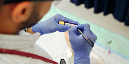 	Doctor writing on a blood sample vial