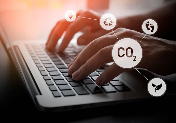 Fingers on laptop keyboard and image has icons of CO2, recycling and green plant.