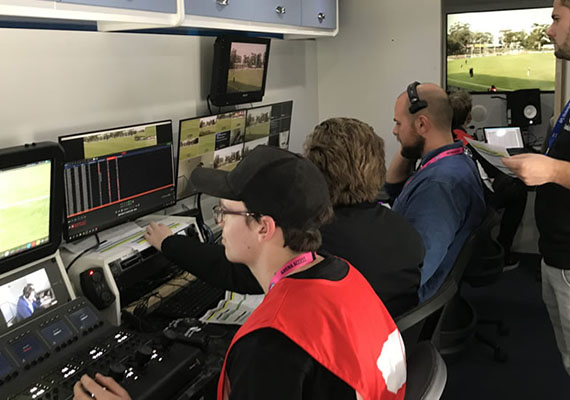 Students look at screens while working in Deakin's Outside Broadcast Van for a VFL game.