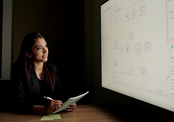 Deakin student mansi chaudhary looks at screen on campus.