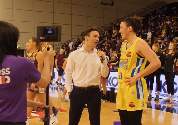 Deakin Bachelor of Arts (Journalism and Public Relations) student, Liam, interviewing a basketball player during the half time break.