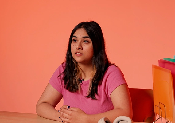 Deakin international student shruti talking in video at desk.