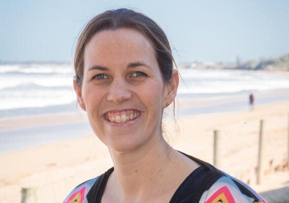 Person smiling into camera at beach