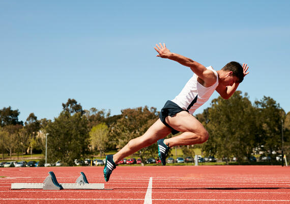 Deakin student athelete taking off running on a campus sport track.